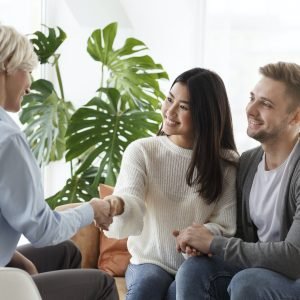 couple-shaking-hands-with-counselor-thankful-for-help-in-office.jpg